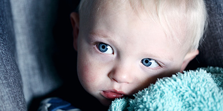 Baby with blanket looking to the side