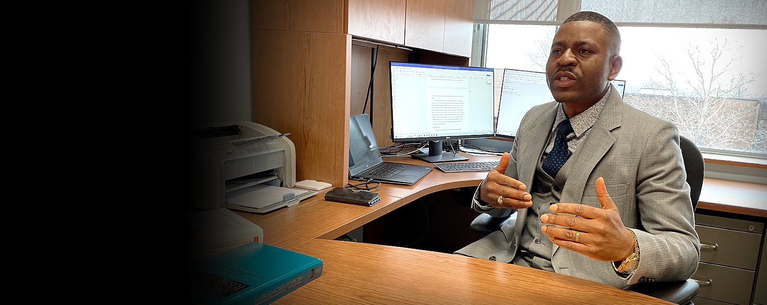 Dr. Eric Tanlaka at his office desk explaining the role of nurses in stroke rehabilitation units