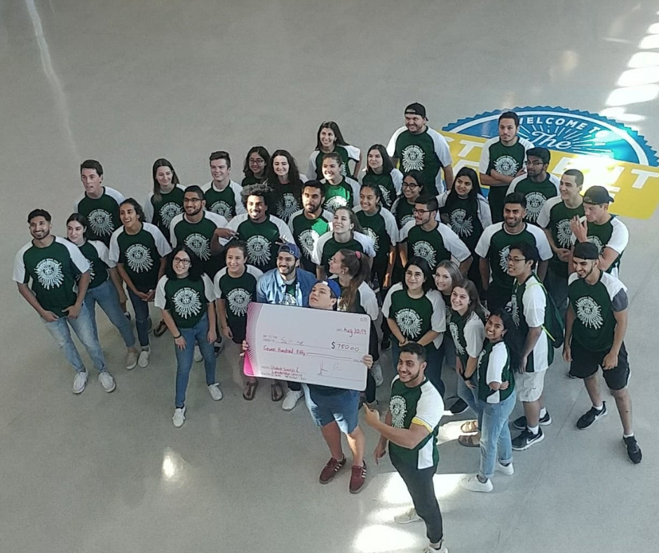 Science society holding a cheque in the CAW student centre