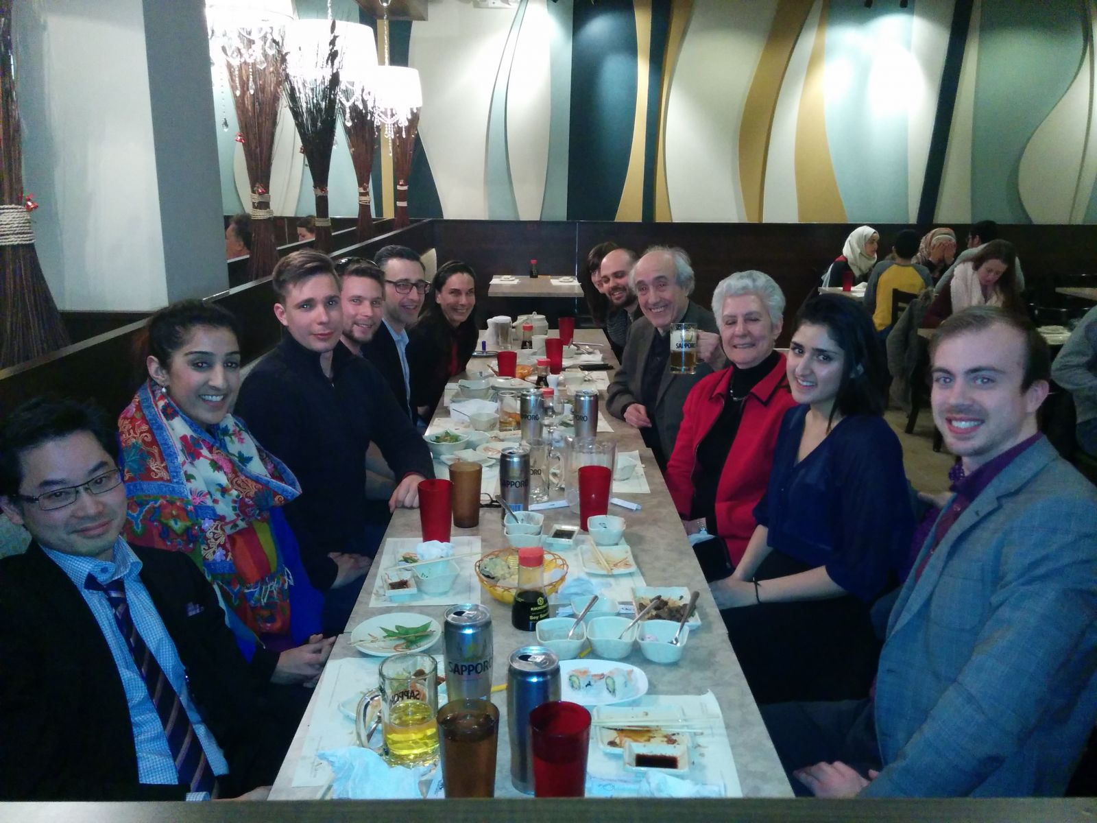 Lab members, Dr. Pascual-Leone, and faculty members seated at a restaurant