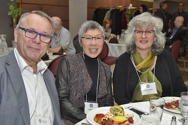 A male and two female employees celebrating years of service