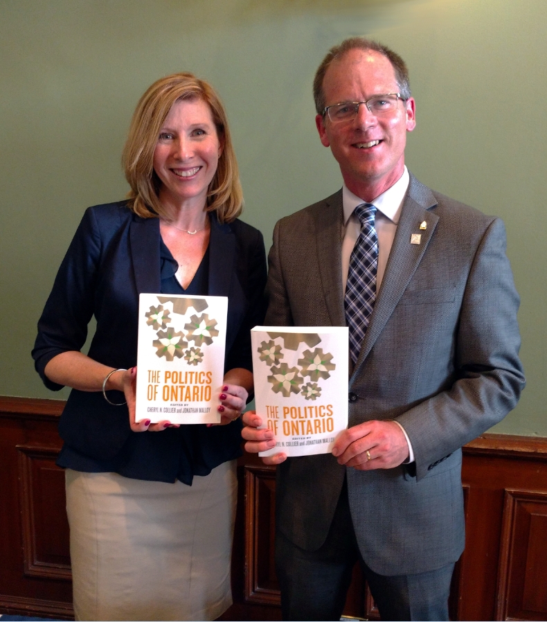 Dr. Cheryl Collier and Dr. Jon Malloy holding a book.