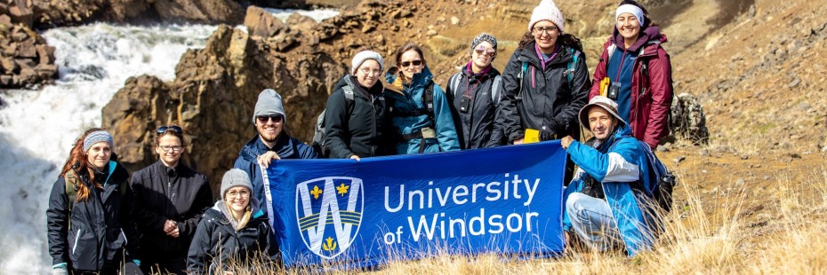 uwindsor staff holding a uwindsor banner in iceland