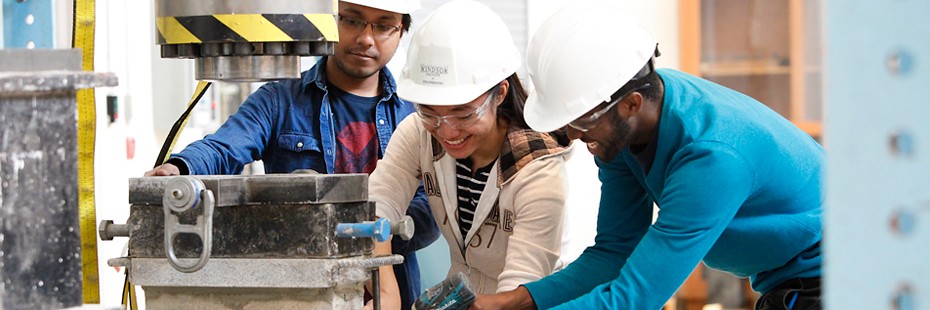 image of three people with safety gear working on civil engineering equipment