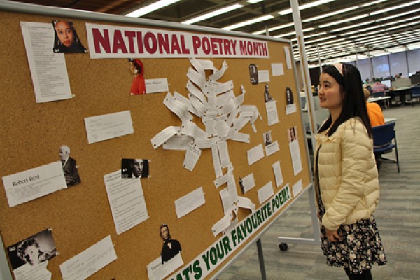 Dannie Peng looking at poetry display in Leddy Library