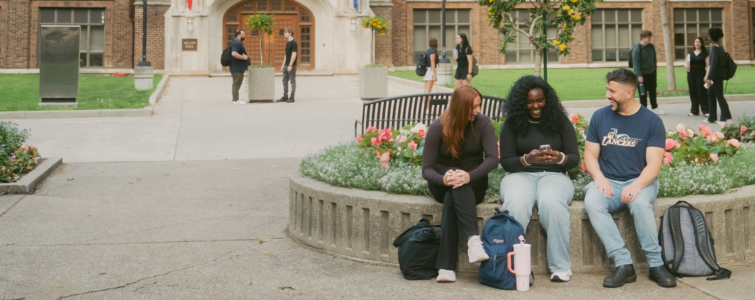 Groups of students talking to one another in front of Dillon Hall