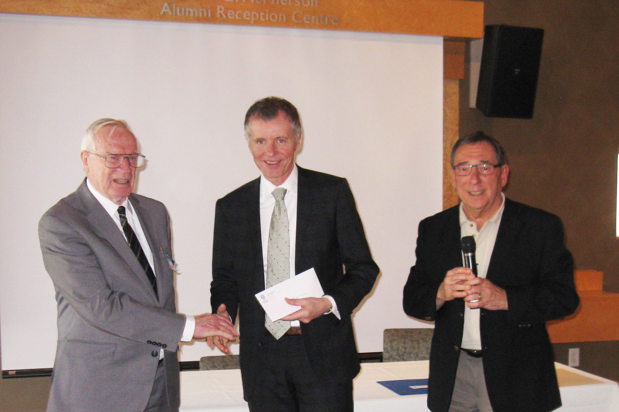 UNI-COM coordinator Bill McRae ( l) and President George Plantus (r) presented Dr. Wildeman with this year’s UNI-COM scholarship donation of $5000.