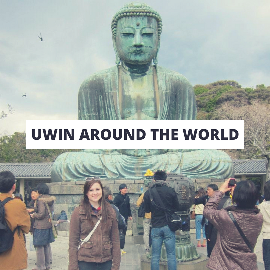 Student in Asia with a giant Buddha 