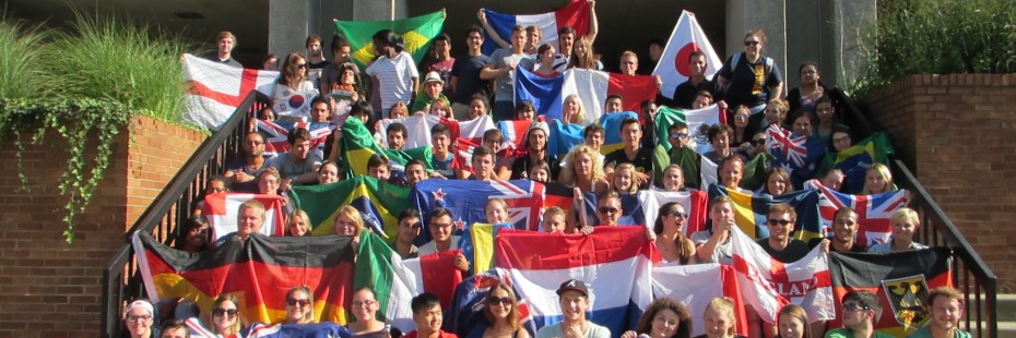 Group photo of incoming exchange students on stairs with their flags.