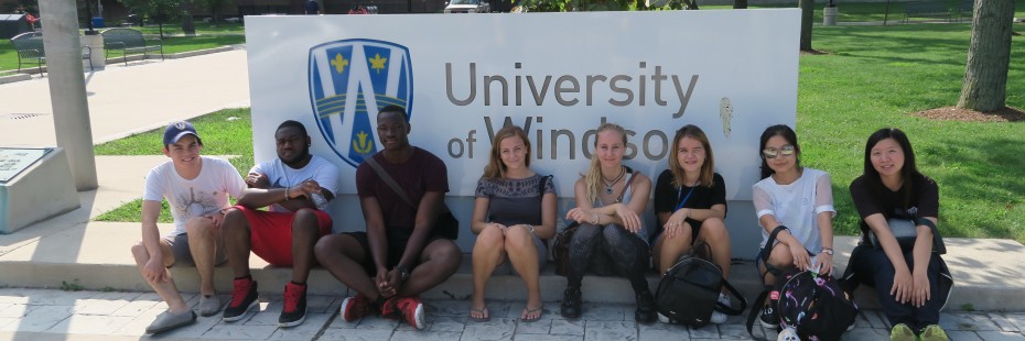 Group shot of incoming exchange students in front of UWindsor sign