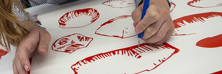 Student creating an image by scraping off colour coating