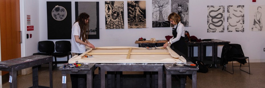Lisa Baggio and student prepare a large canvass in the studio