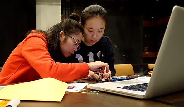 2 students working with an arduino