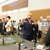 Habib Haider explains his group project, a system designed to reduce the impact of long lines waiting to access the Gordie Howe International Bridge, to professor Hanna Maoh of the Cross-Border Institute.