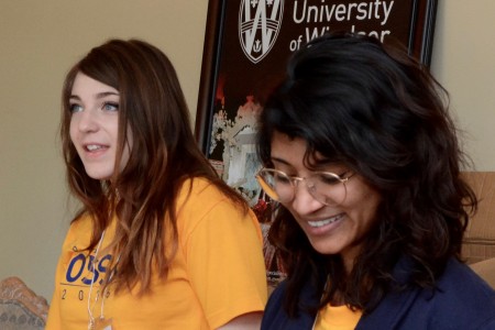 Two students smile as they volunteer at an argumentation studies conference