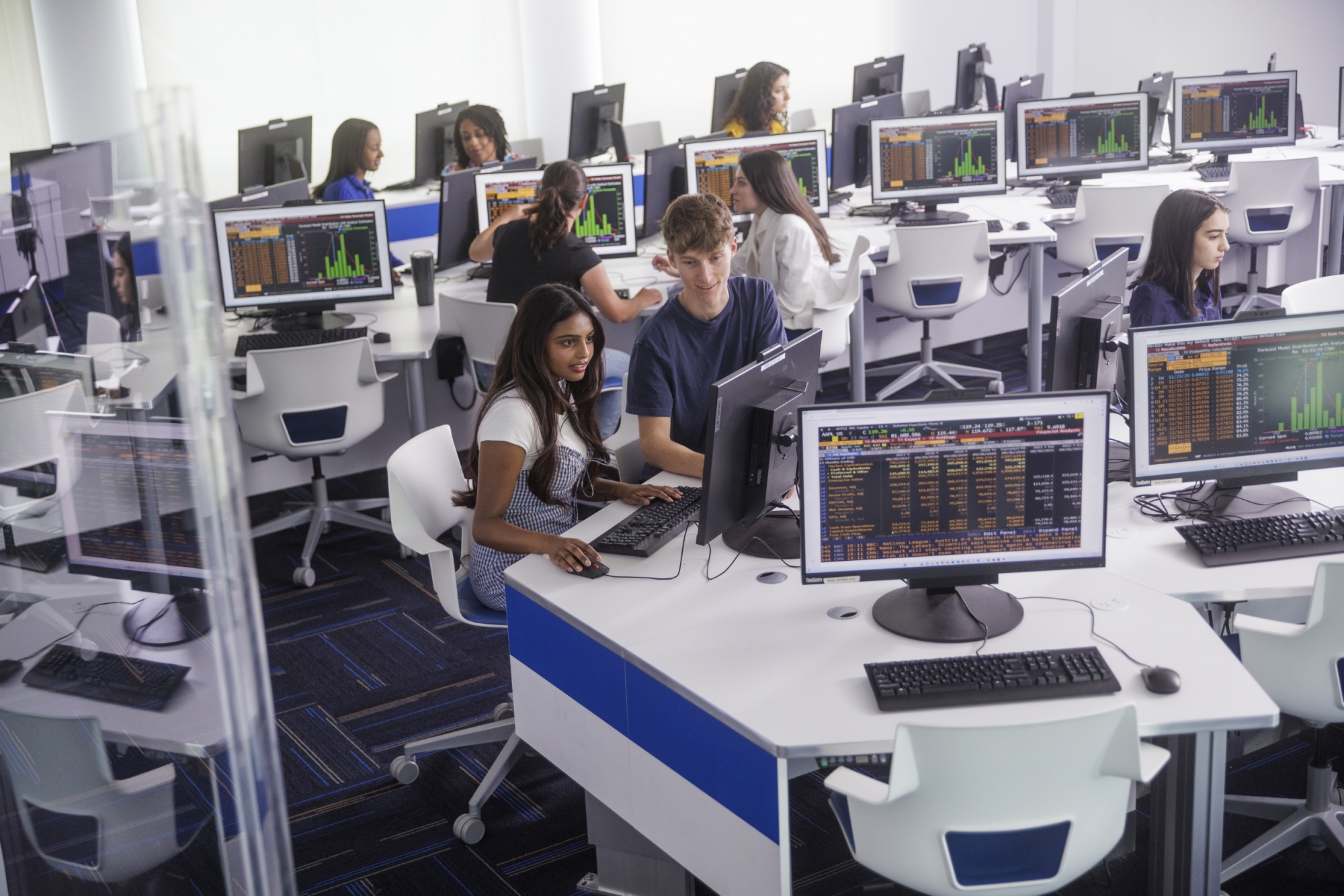 Students at computer stations in the data analytics lab, with graphs up on the screens