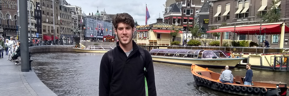 Student on exchange in front of a river with boats