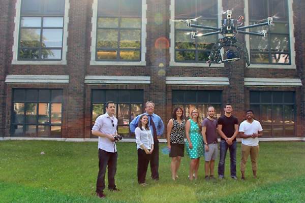 Students and staff watch drone hover outside Dillon Hall.