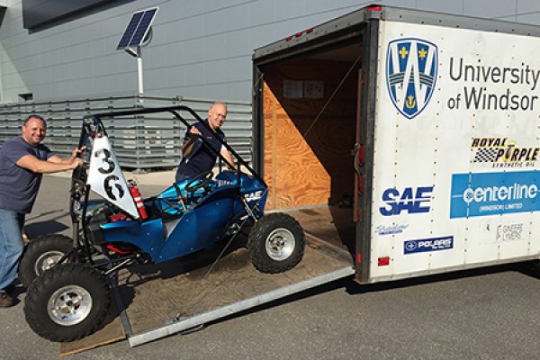 Dean Poublon and Bruce Durfy load the student-designed and -built Baja vehicle into a truck.