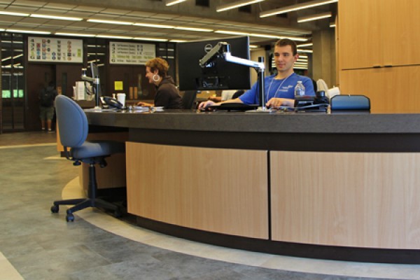 Librarian Selinda Berg and student IT consultant Tomas Dobos staff the Leddy Library service desk.