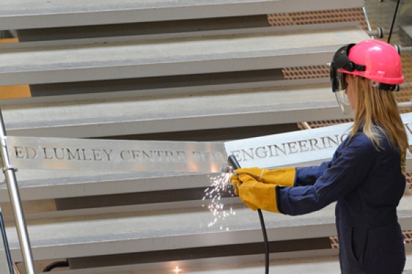 Lotus Pupulin uses a plasma torch to cut through an aluminum ribbon.