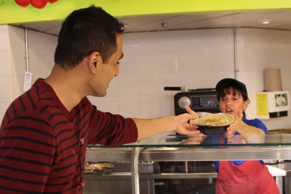 Fourth-year business major Rafae Khan accepts a dish of made-to-order pasta from server Marisa Isabella, Tuesday in the CAW Student Centre.