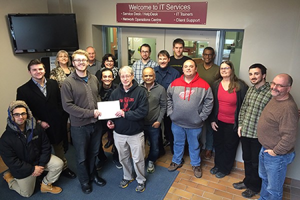 IT Services staff surround Club SODA president Billy Chandler as he presents a certificate of appreciation for the department’s work to Andy Kozak.