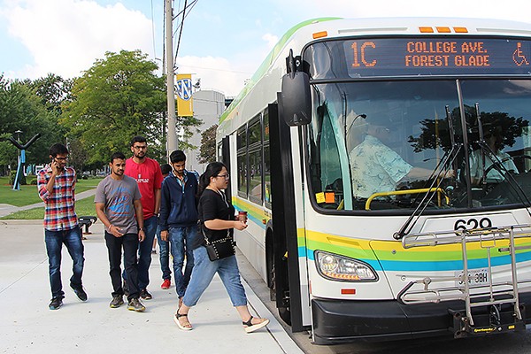 Students board a bus bound for downtown, Friday on University Avenue.