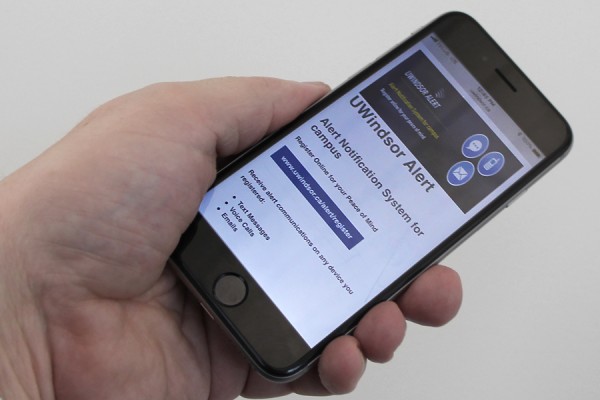 hand holding smart phone displaying UWindsor Alert