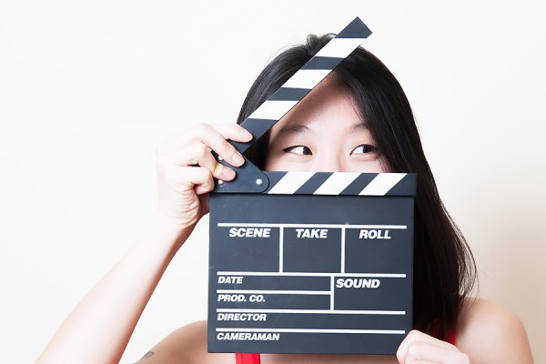 woman holding clapboard before her face