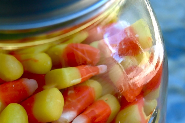 Jar filled with candy corn.
