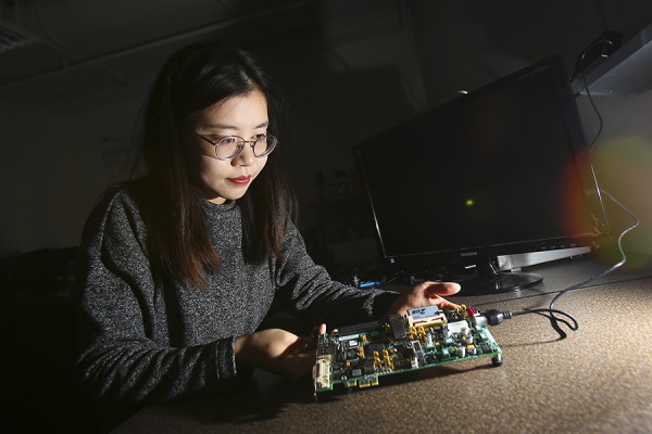 Meitong Pan examines a board used to implement complex digital computations.
