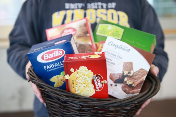 hands holding basket of foodstuffs