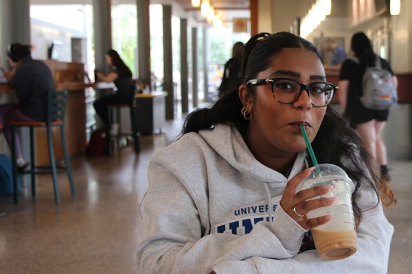 student sipping iced coffee
