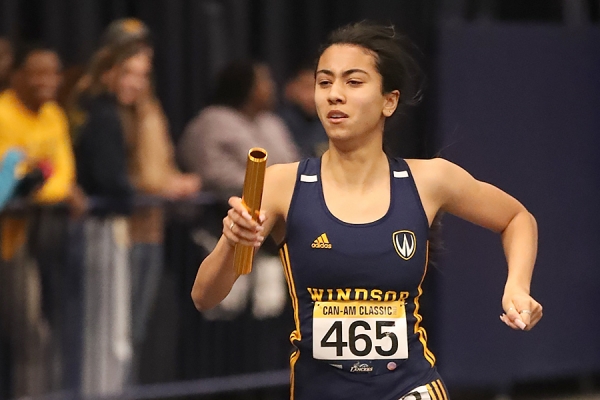 Maya Metivier running with relay baton