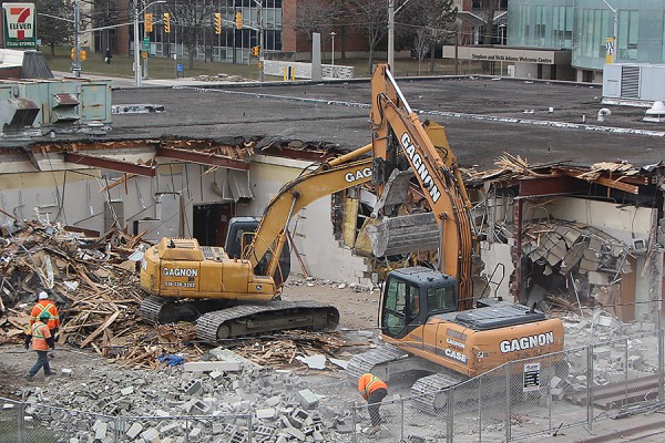 Demolition of the former Music Building advanced Tuesday, with excavators removing exterior and interior walls.