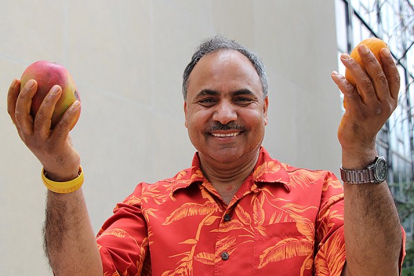 Siyaram Pandey holding up mangoes