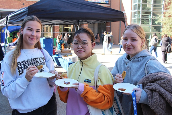 Mathilda Rosell, Michelle Lam, and Lina Patriksson eat samosas