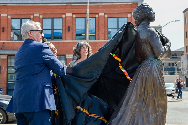 Robert Gordon, Marium Tolson-Murtty, and Donna Mayne pulling cloth off statue.