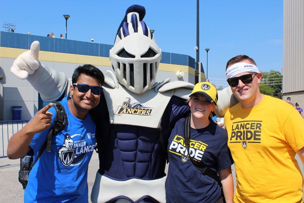 students standing with Lancer mascot