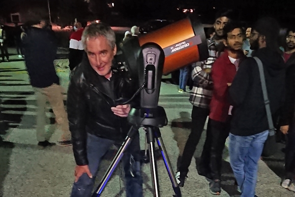 Jeff Peacock prepares telescope for line of viewers.
