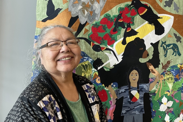 Teresa Altiman stands with her textile artwork