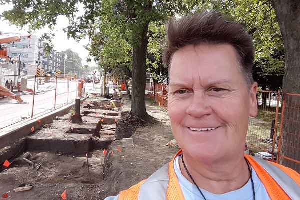 Terri Fletcher standing in front of dig site along Sandwich Street.