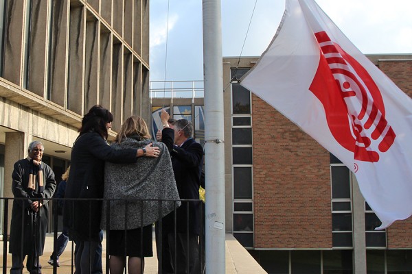 UWindsor and United Way officials raise the charity’s flag outside Chrysler Hall Tower to kick off last year’s fundraising effort.