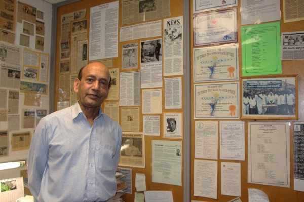 Retired UWindsor librarian and sessional instructor in economics Dr. Tad Venkateswarlu poses with numerous news clippings about his Tenali School Project.