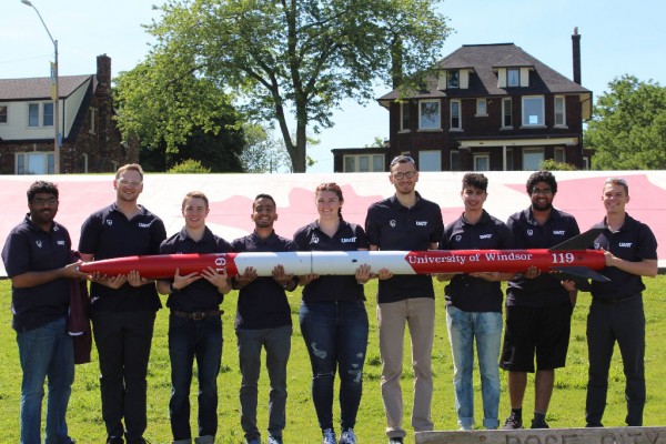 University of Windsor mechanical engineering students pose with the rocket they entered in The Spaceport America Cup. The team placed fifth in the 30,000 commercial off the shelf motor, solid propulsion category.