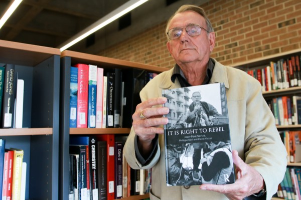 Professor emeritus Adrian van den Hoven displays It Is Right To Rebel by Jean-Paul Sartre, Philippe Gavi and Pierre Victor. Van den Hoven and professor emeritus Basil Kingstone translated the book from its original French to English.