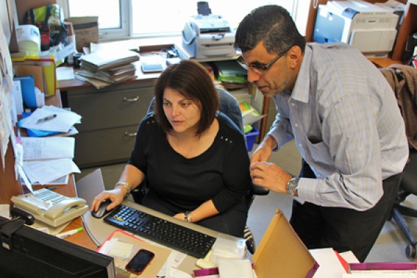 Susan Rotondi and Maher El-Masri shuffle papers at desk