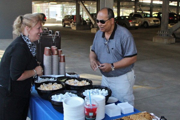 Laurie Butler-Grondin distributes coffee and cookies to a patron of the new campus parking garage.