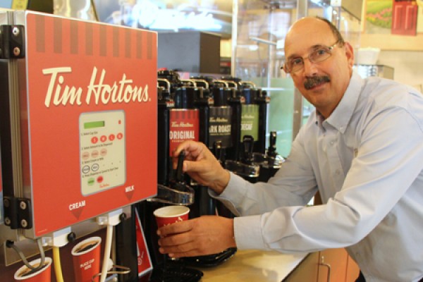 Mark Bagley, manager of satellite operations, tests new Tim Hortons self-serve coffee carafes after their installation Friday in the Marketplace.